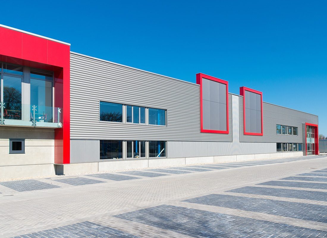 Business Insurance - Modern Business Warehouse With a Red and Gray Metal Exterior on a Sunny Day