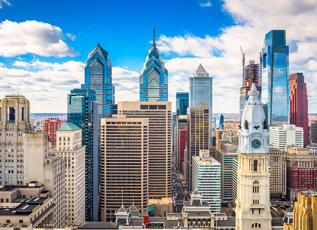 Contact - Philadelphia Skyline Displaying Many Tall Buildings on a Sunny Day With Some Clouds