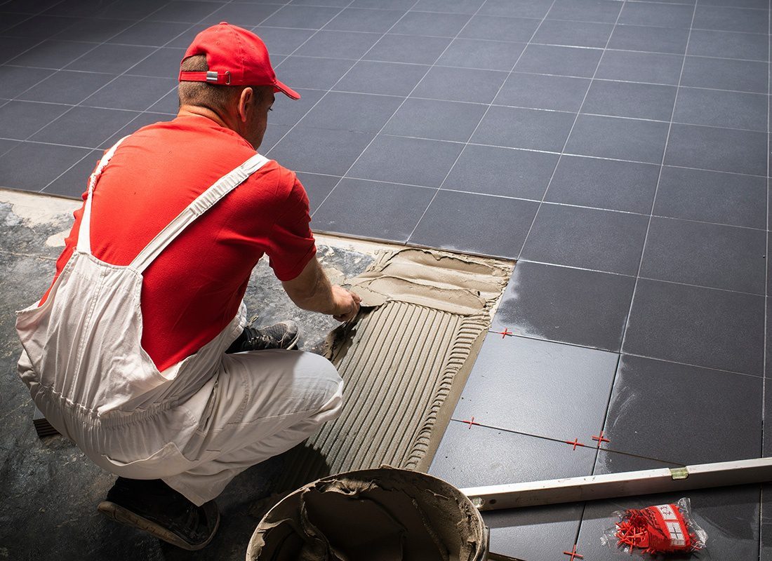 Insurance by Industry - Contractor Installing Ceramic Tiles on a Floor
