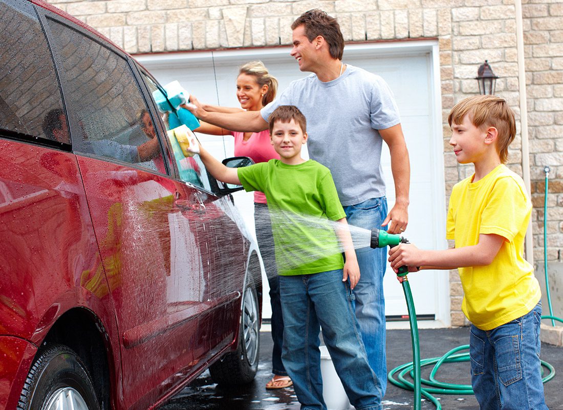 Personal Insurance - Happy Family Wash Their Car Together in Front of Their Home